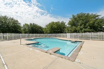 A large outdoor swimming pool surrounded by a fence.